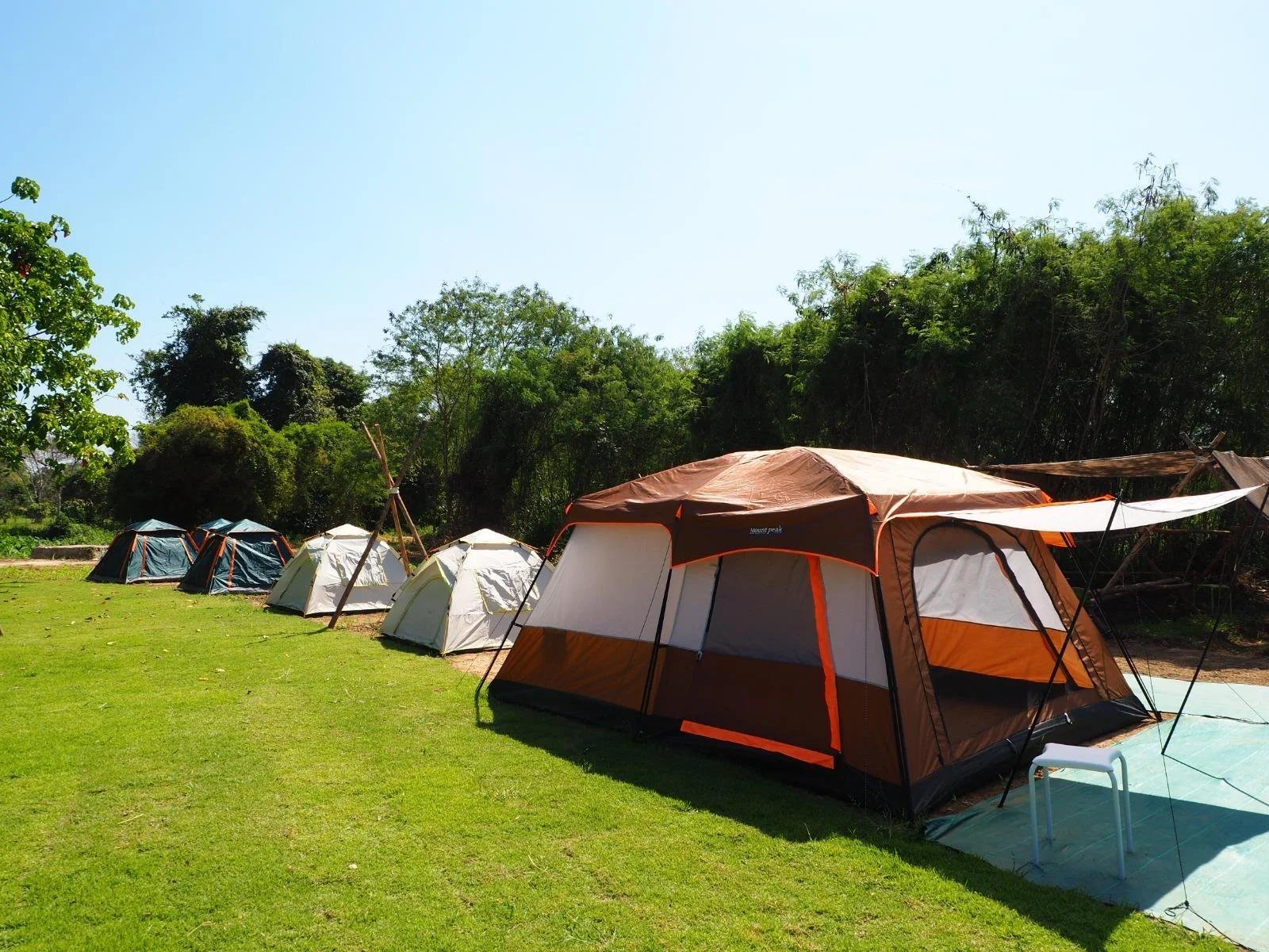 Firefly Camping pitches on manicured lawns under blue skies